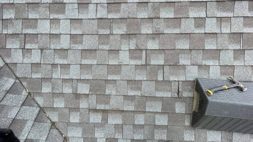 Worn asphalt shingles and a moss-lined valley on a Hermantown, MN roof inspected by Empire Roofing.