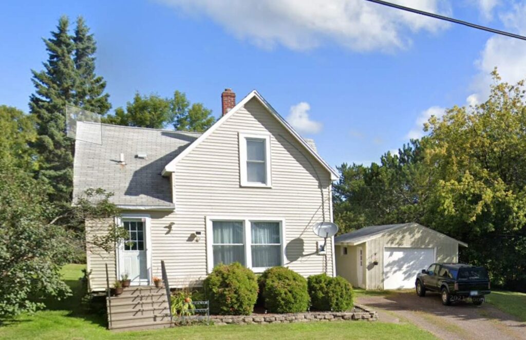 Traditional lap vinyl siding on a story-and-a-half home with a detached garage in Duluth.
