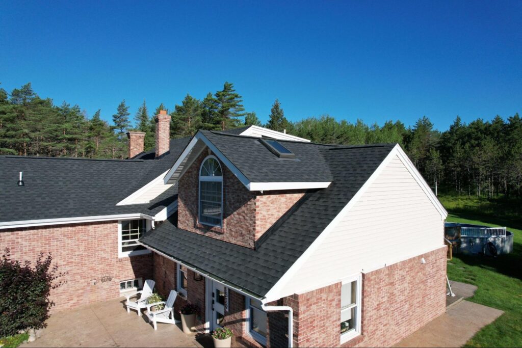 Asphalt shingle roof installation on a brick home with a dormer and skylight in Duluth, MN.