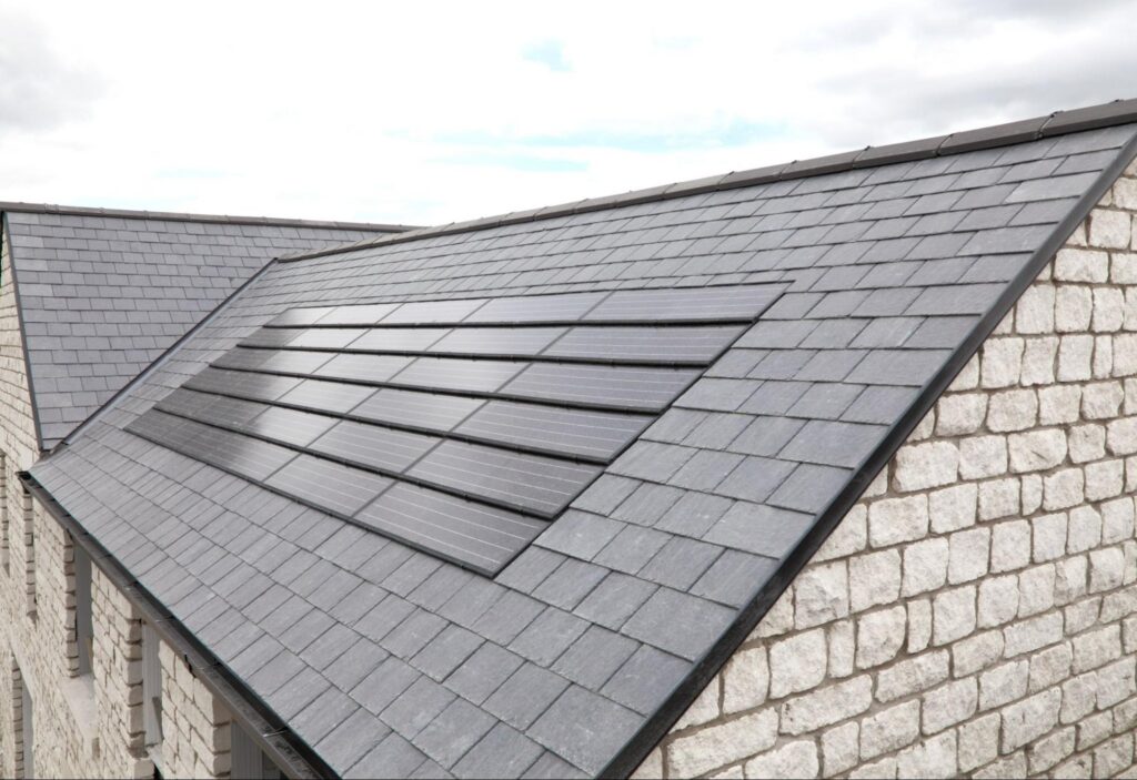 Integrated solar roofing blended into a dark roof on a stone home in Duluth, MN.