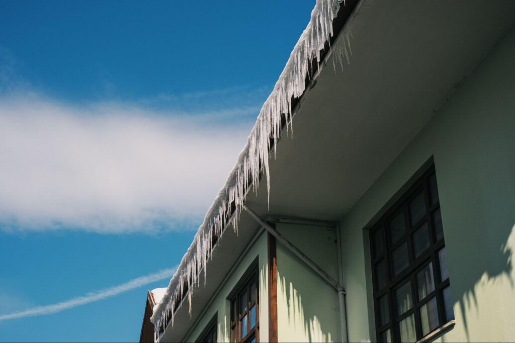 Long icicles hanging from a roof edge, an early warning sign of ice dams